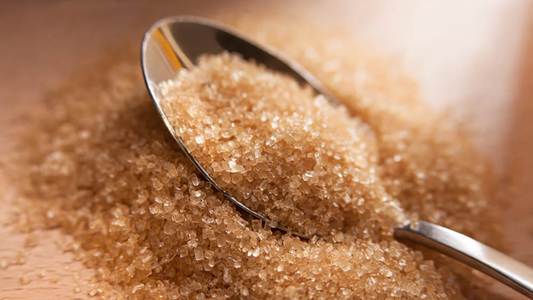 A heaping pile of organic sugar cane with a silver spoon in the middle